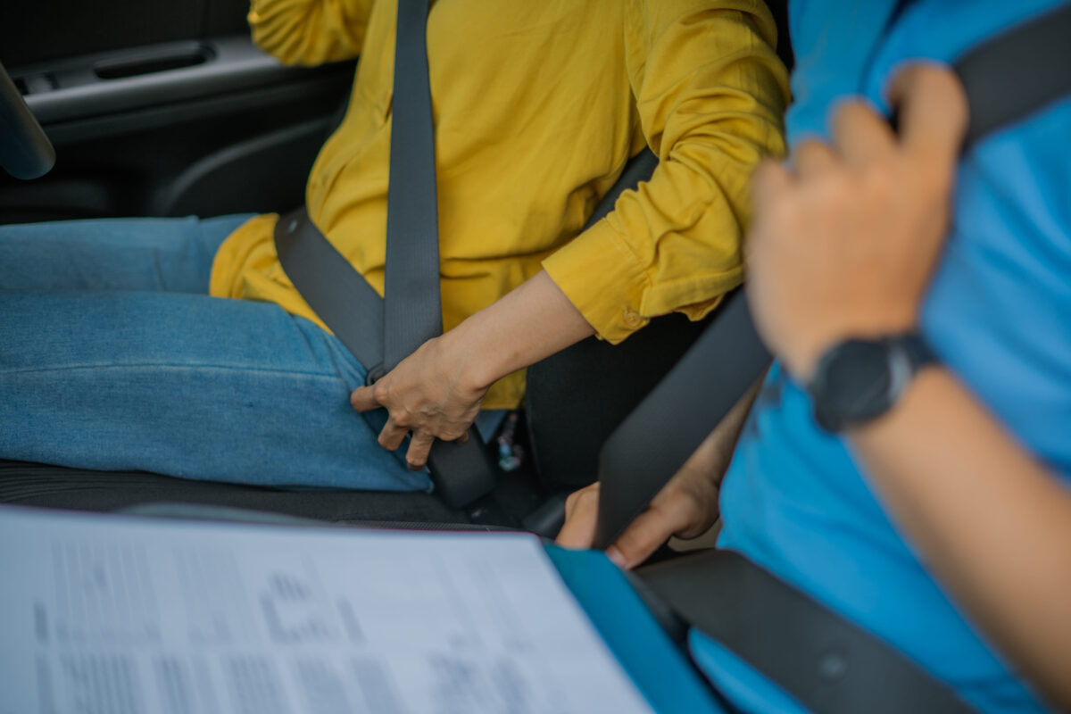 A closeup view of several individuals securely fastening their seatbelts inside a vehicle