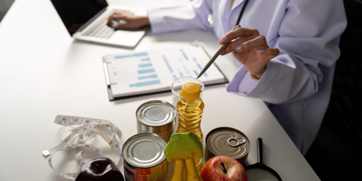 Health and Nutrition Evaluation. A healthcare expert analyzing food items and health charts while utilizing technology for dietary advice.