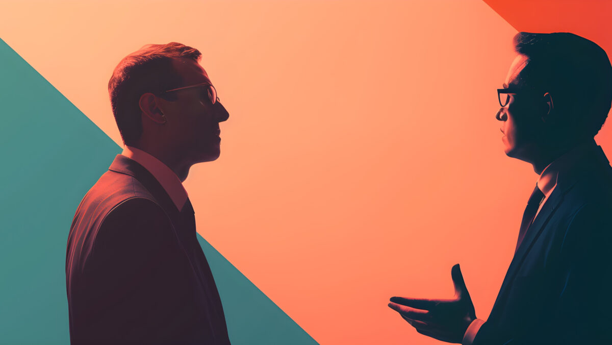 Portrait of two business people looking at each other on color background