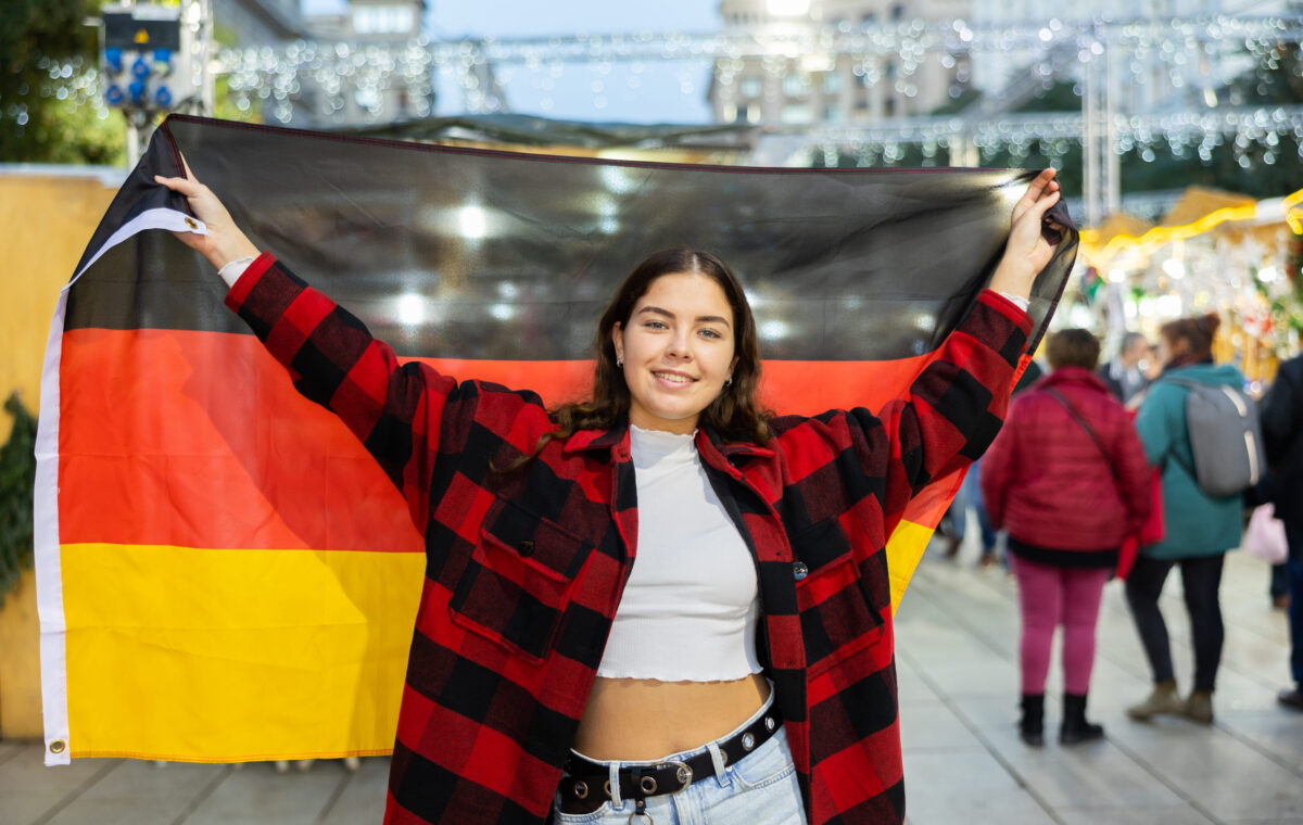 8 High-Tax Countries That Make Ordinary Life Brutally Expensive 4 Happy girl with German flag in city Christmas fair