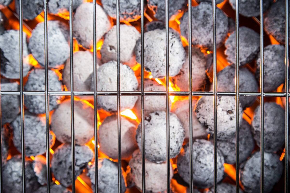 Garden grill with blistering briquettes, close-up.