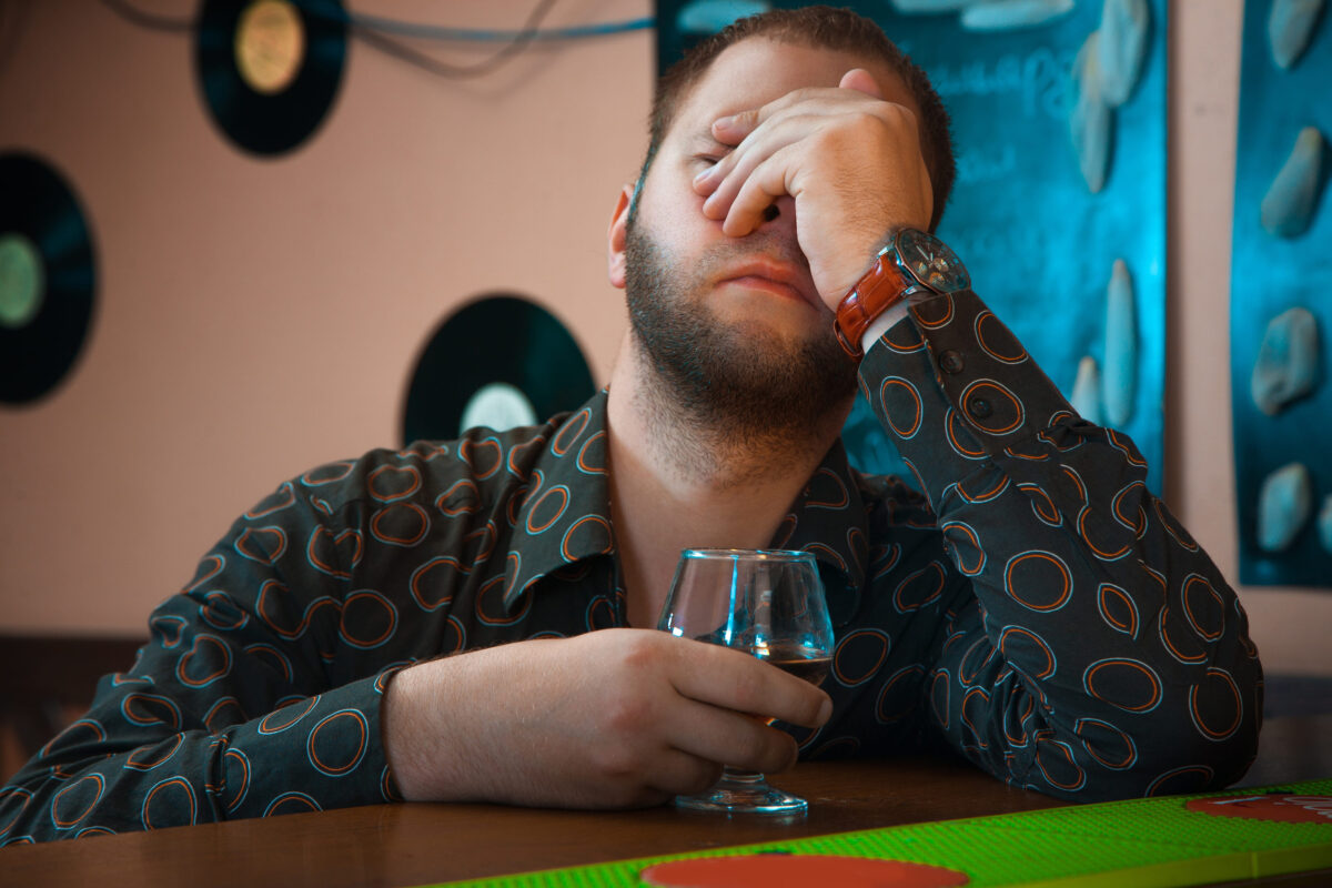 horizontal Photo of Drunk man with a glass of brandy at the bar. horizontal photo