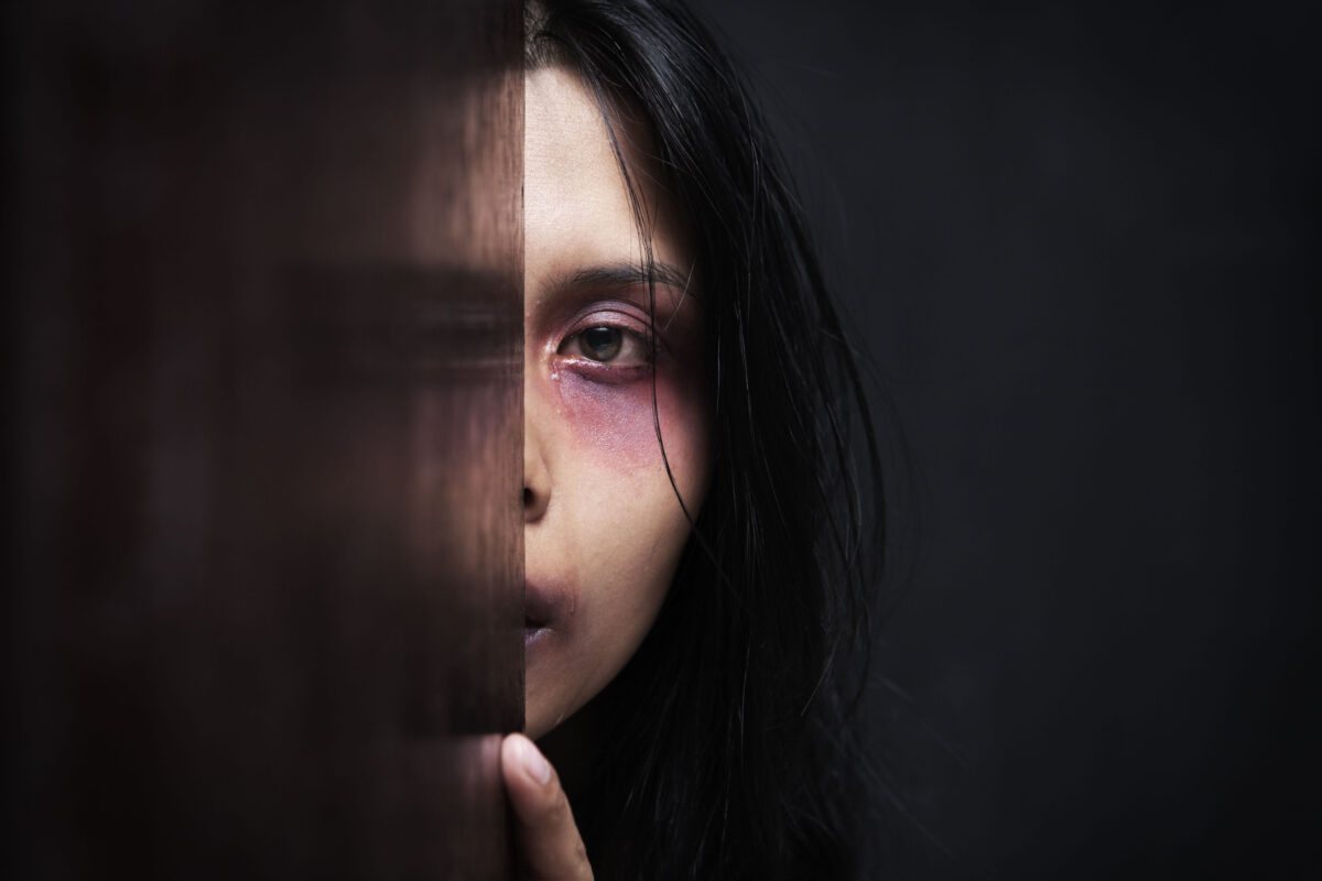 Injured woman hiding in dark, concept for domestic violence