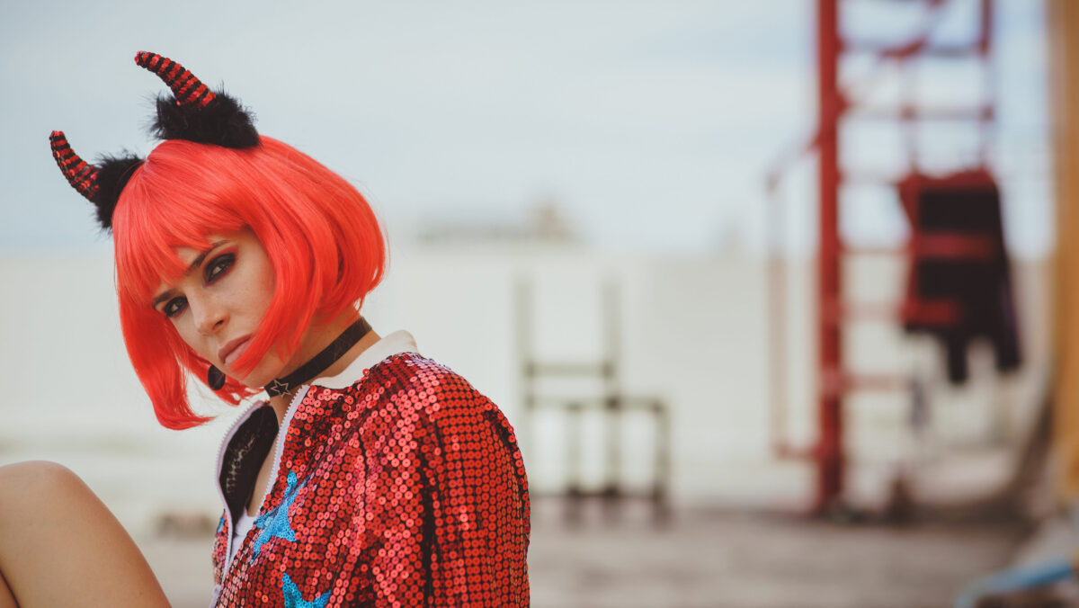 8 Most hated social media influencers of all time 3 Halloween. Portrait of a beautiful girl in a red wig with horns closeup. Red, festive makeup.