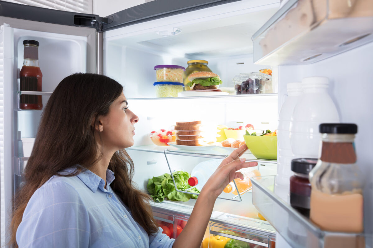 Close-up Of A Young Woman Looking At Fresh Food In Refrigerator