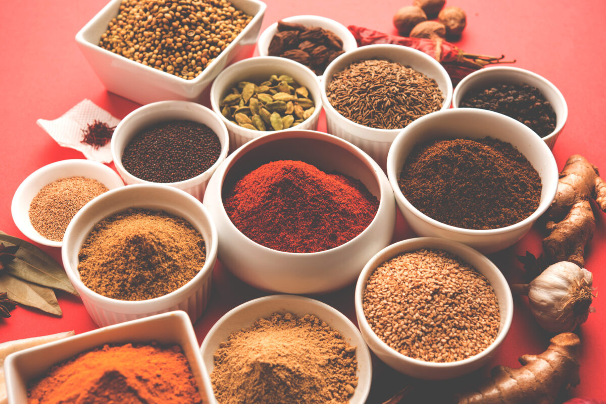 Raw Indian Spice Powder over red, yellow or green  background, selective focus