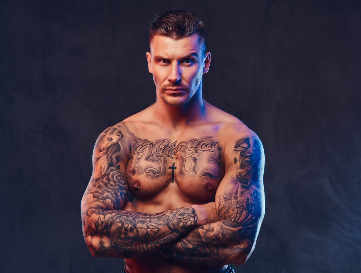 10 Worst Tattoos People Regret Having 3 A muscular tattooed man over dark background.
