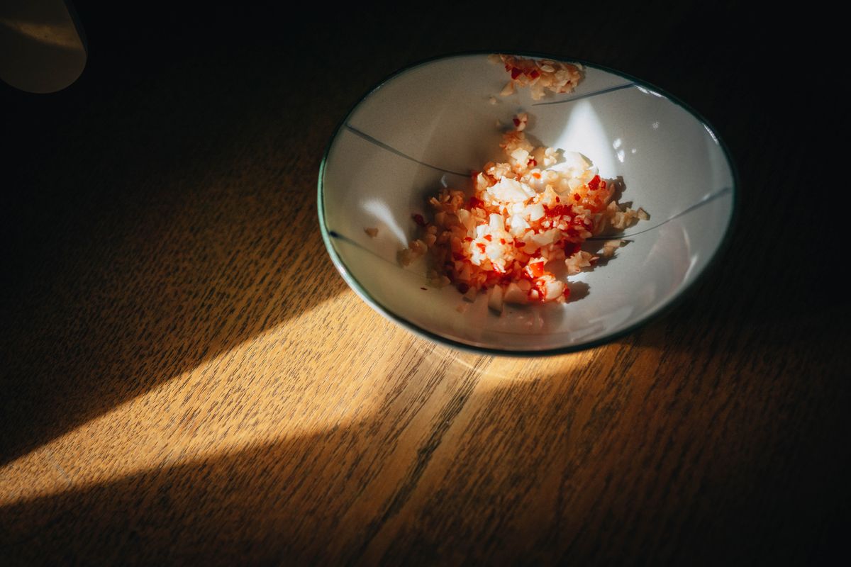 9 Dangerous Foods in Your Refrigerator That Can Make You Sick 4 A bowl with chopped food remnants in warm light on wooden table.