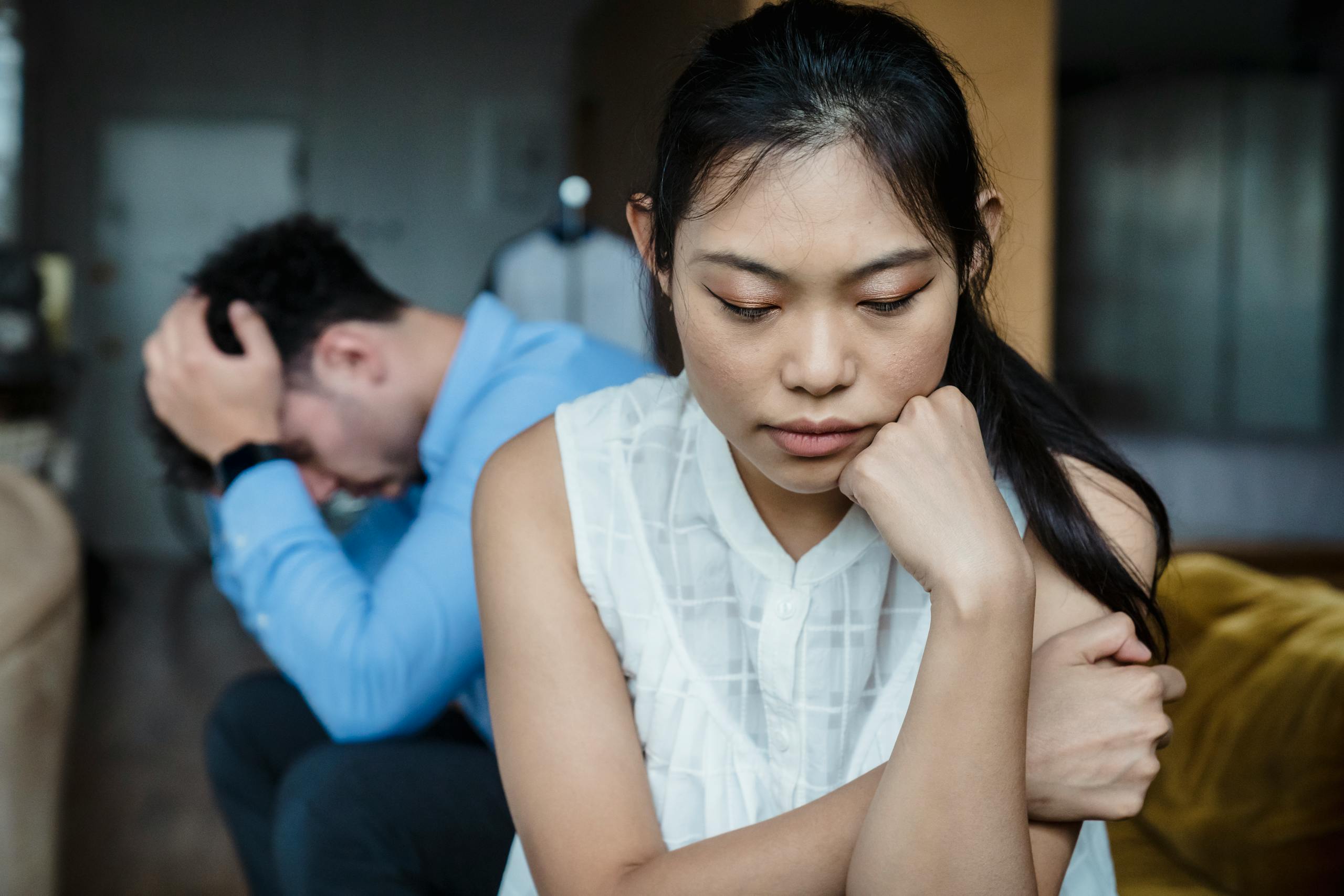 8 Warning Signs Your Relationship Is Quietly Falling Apart 4 A couple experiencing relationship tension sitting silently on a sofa.