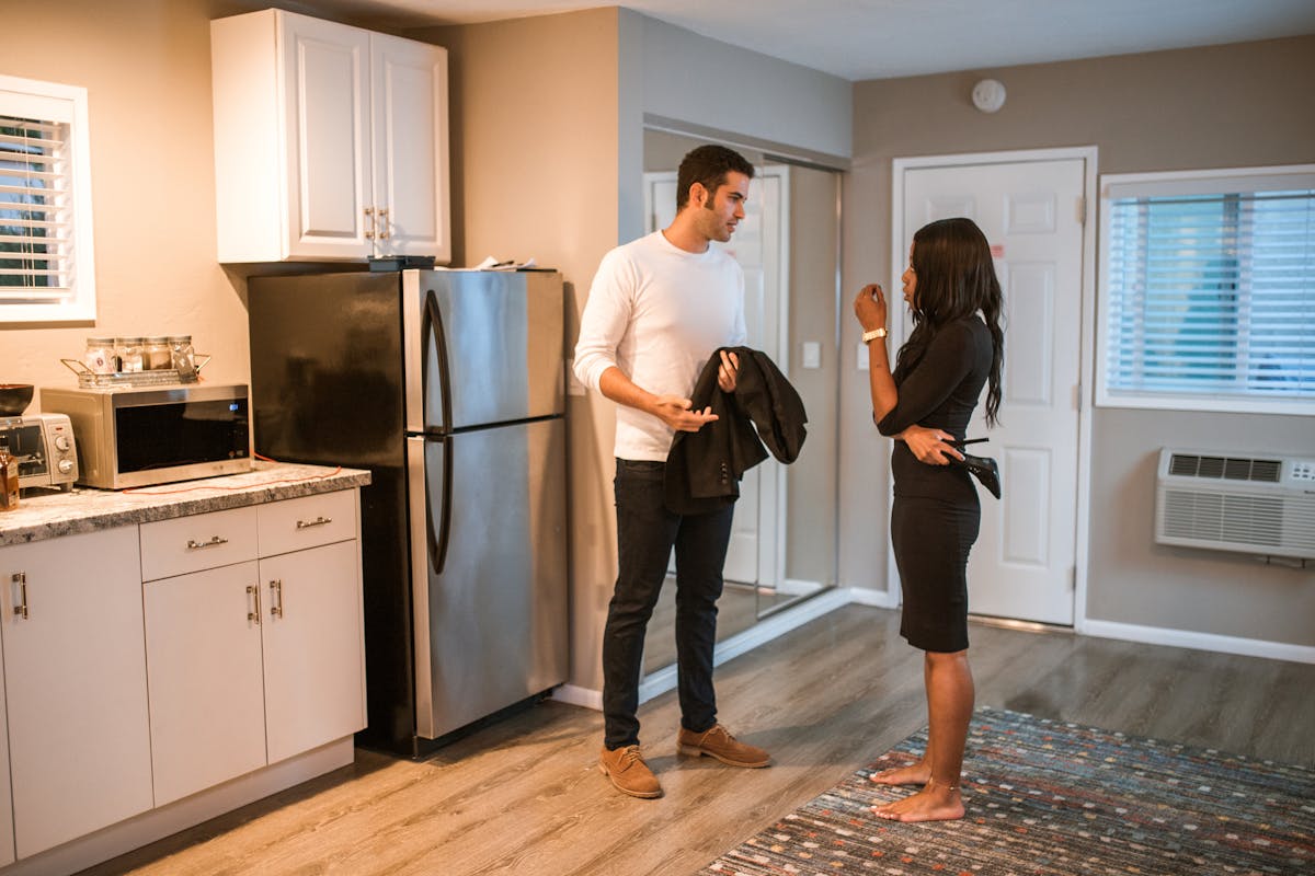 10 Painful Reasons Couples Get Divorced When Love Stops Being Enough 3 A couple having a serious conversation in a stylish kitchen setting.
