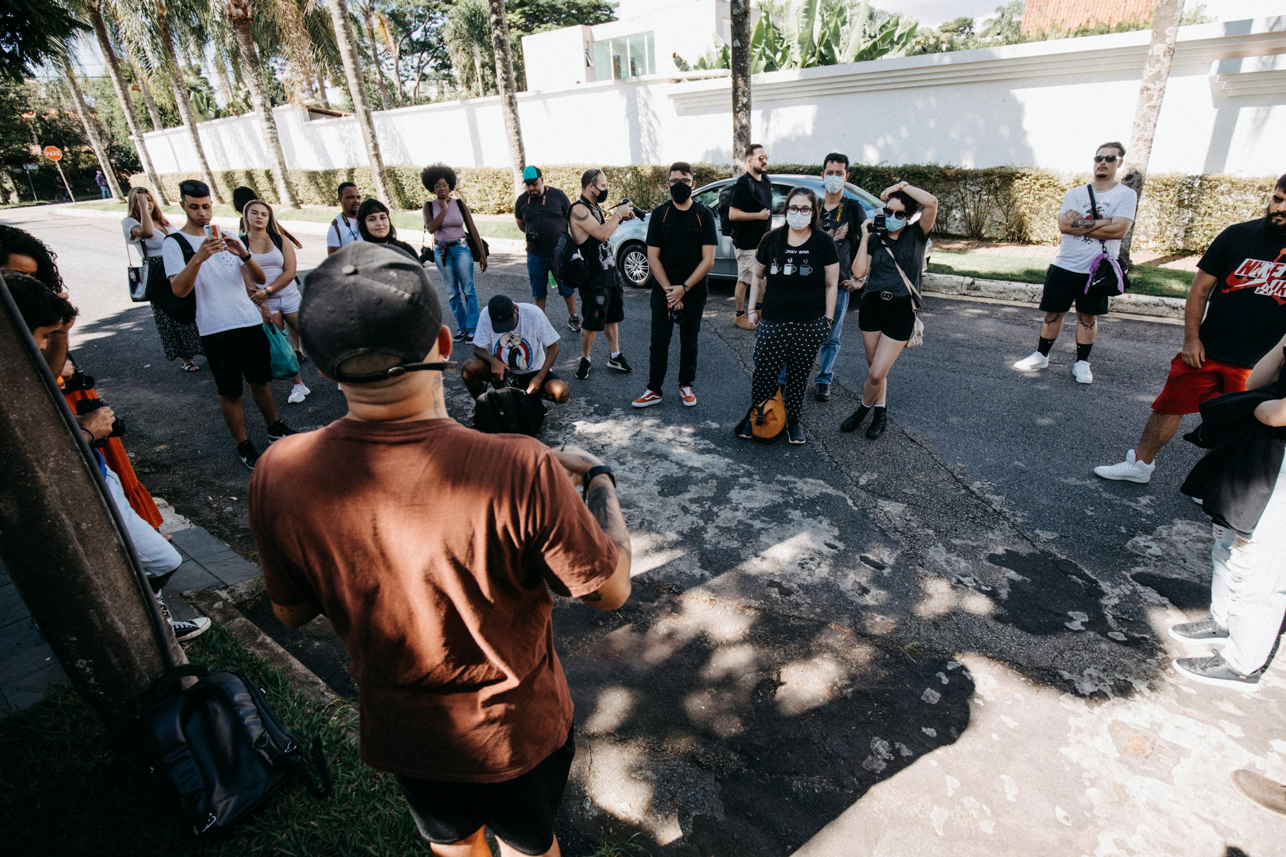 A diverse group of people on a guided tour during a sunny day on an urban street.