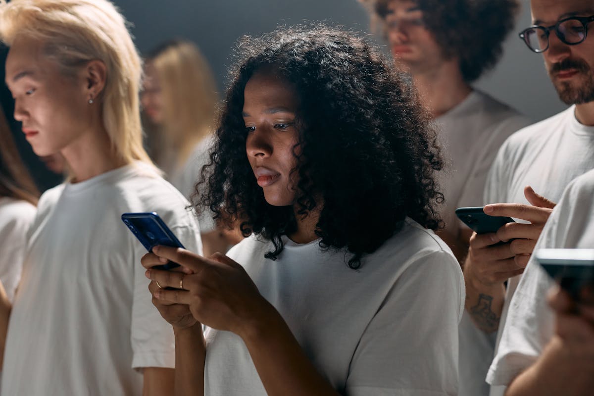10 Online Habits Destroying Your Attention Span Faster Than You Realize 4 A diverse group of young adults focused on smartphones, symbolizing modern social connections and technology.