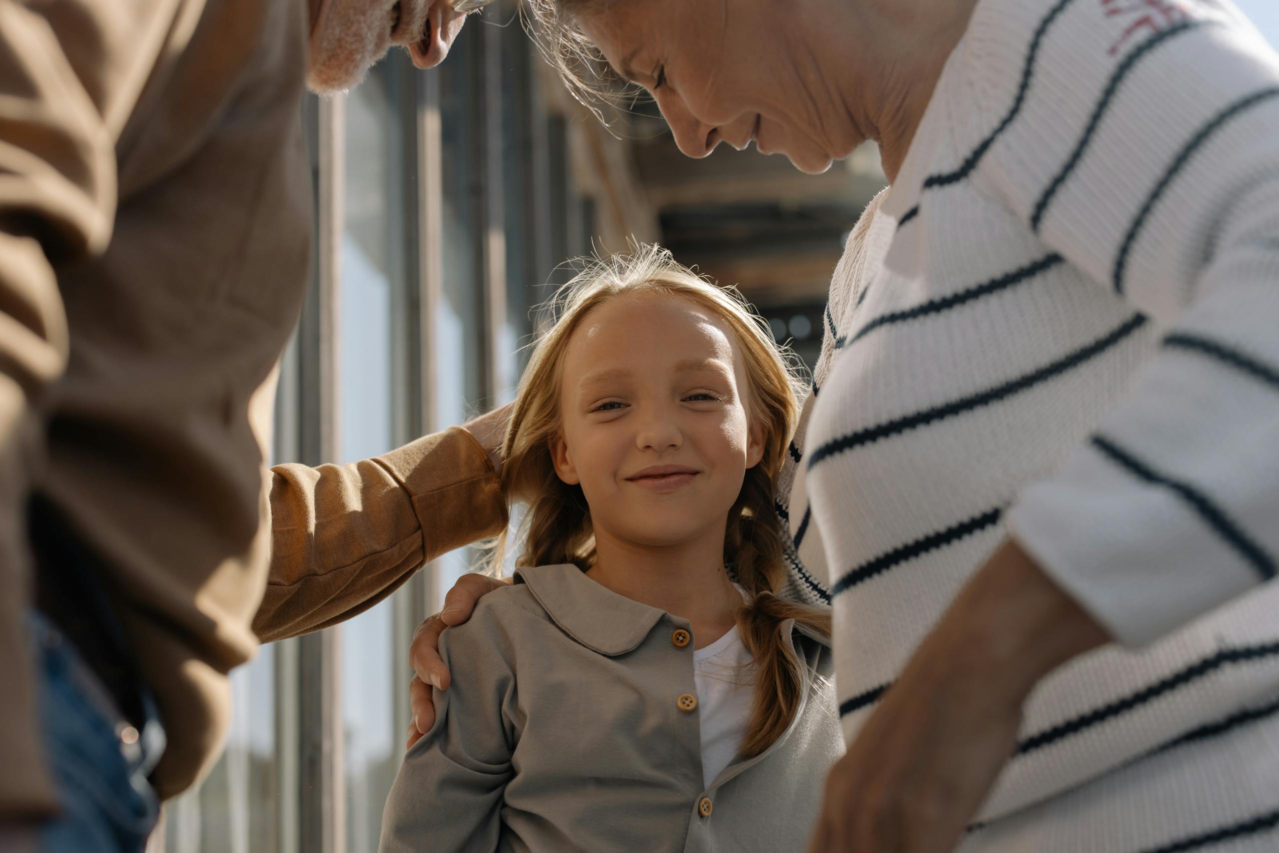8 Shocking Ways Grandparents Are Becoming the New Childcare System 2 A joyful girl embraced by her loving grandparents, smiling and bonding together.