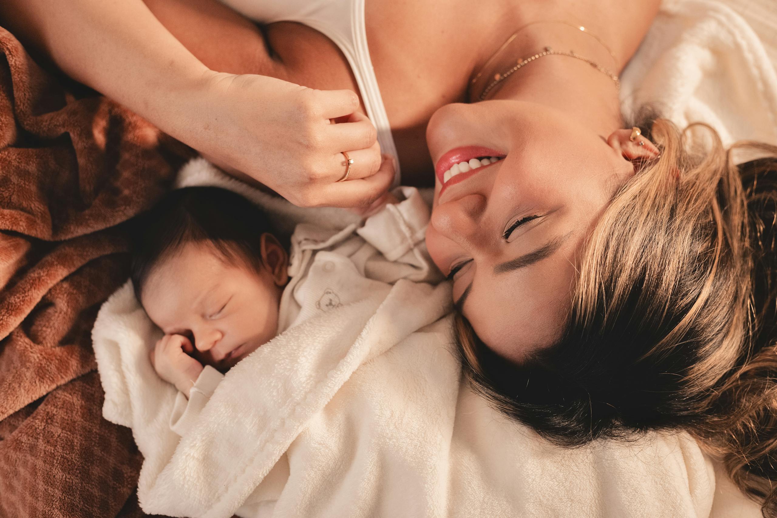 7 Reasons Botox After Pregnancy Can Become a Beauty Decision You Regret 4 A mother and her newborn baby lying peacefully together in a cozy blanket.