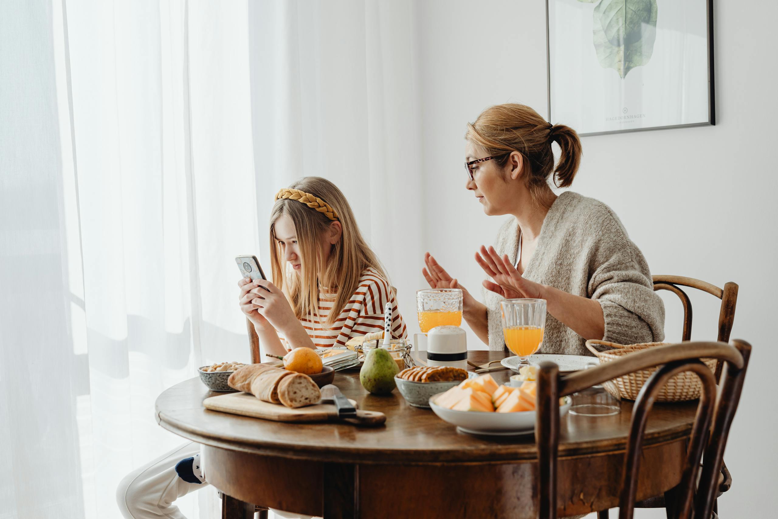 A mother scolding her daughter at breakfast, emphasizing modern parenting dynamics at home.