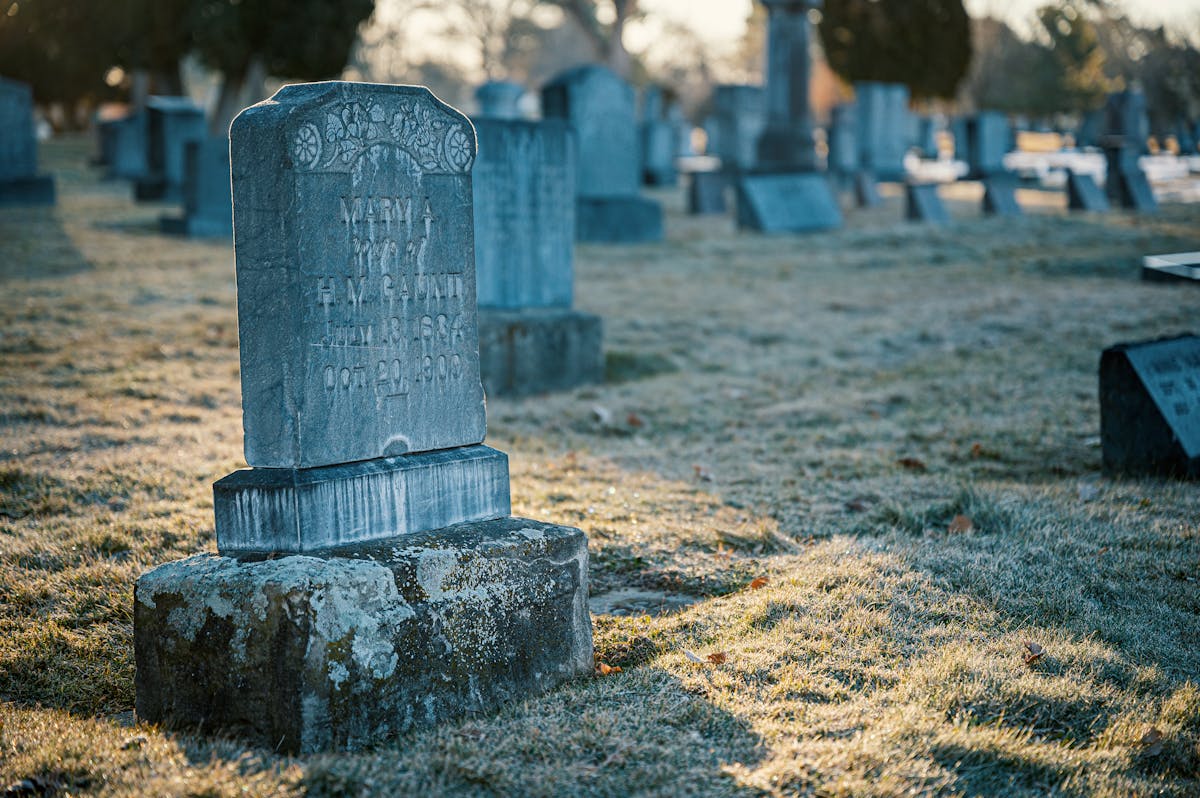 8 Dark Things That Happen When We Die 1 A peaceful cemetery scene featuring an old tombstone on a frosty morning.