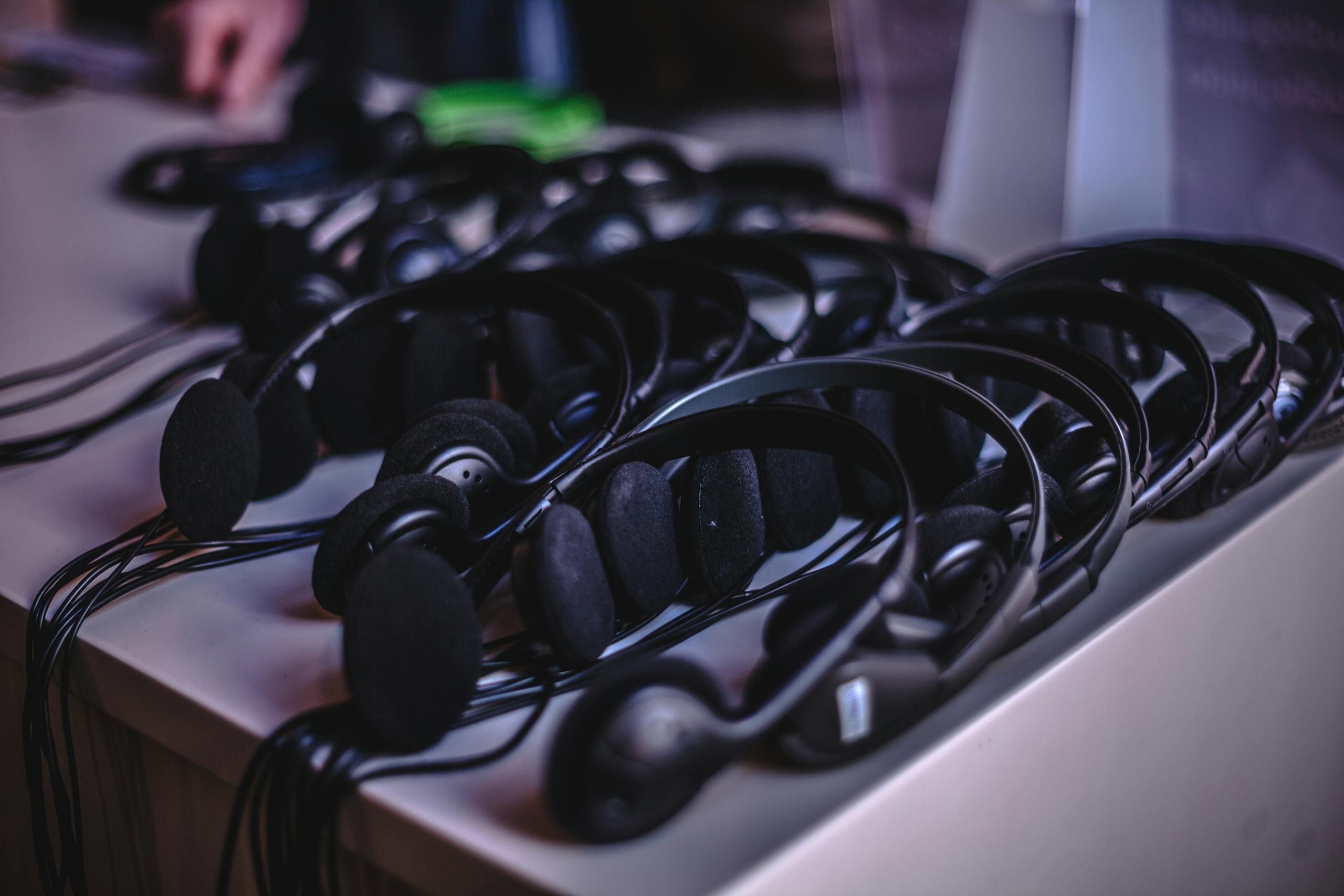 A variety of modern audio headsets neatly arranged on a display table indoors.