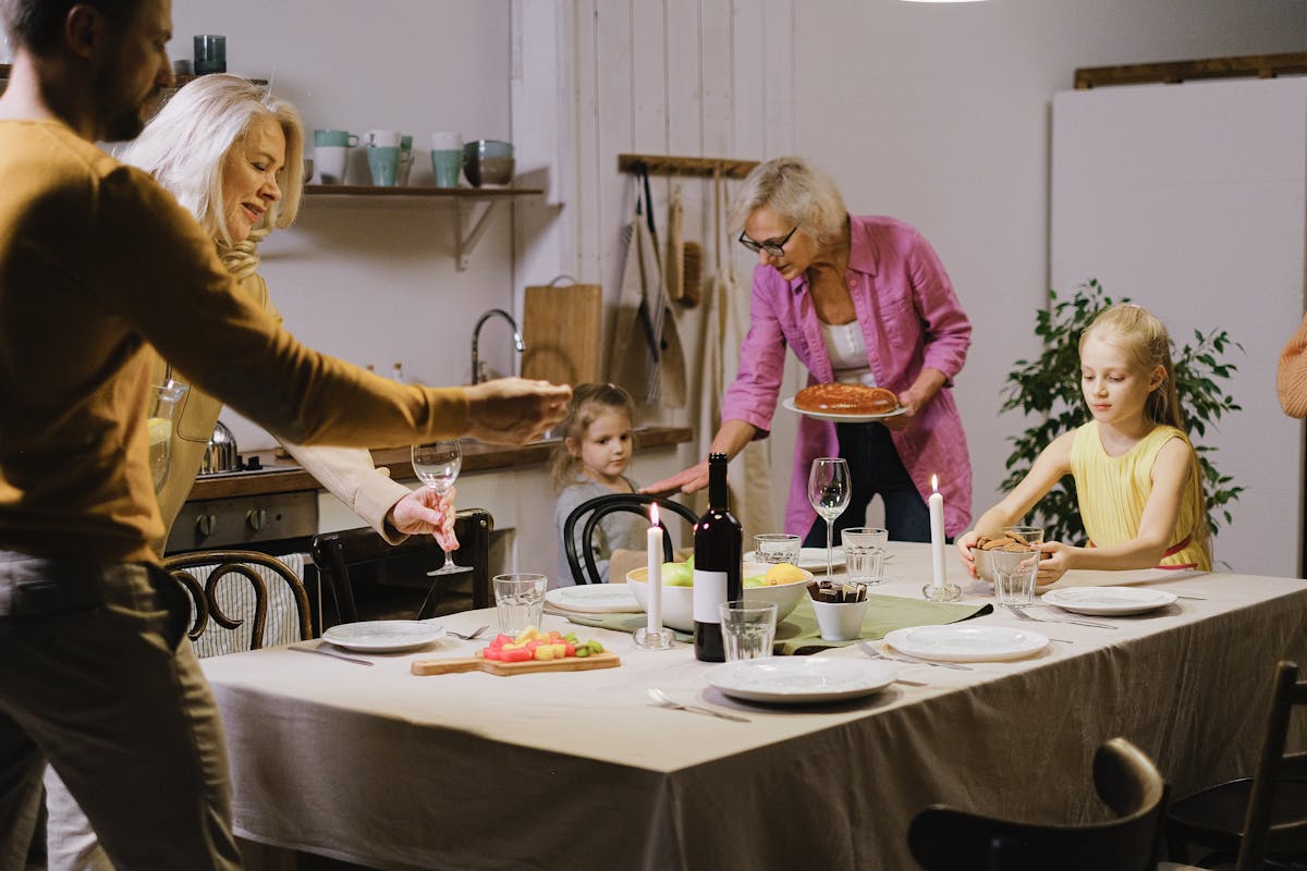 8 School-Night Dinner Routines That Make Family Meals Less Hectic 1 A warm family gathering indoors with multi-generational members enjoying dinner preparation.