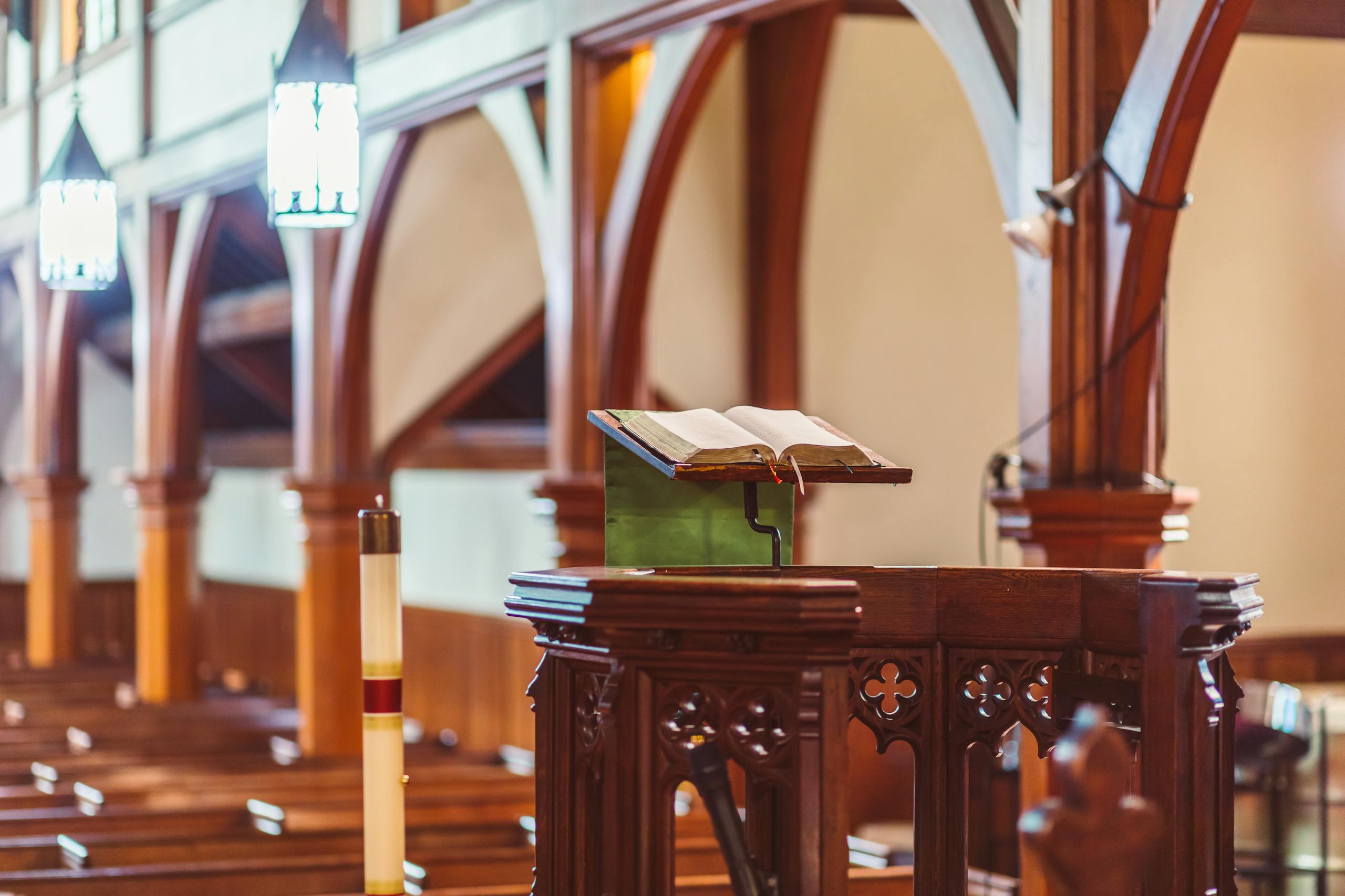 10 Harsh Truths About Why Church No Longer Feels Like Home to Some Americans 1 A wooden pulpit with an open Bible in an empty church setting.