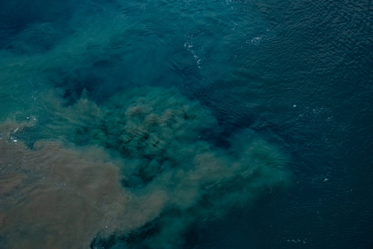 9 Explosive Volcano Facts That Reveal How Strange Earth’s Fire Mountains Really Are 3 Aerial shot of ocean waters highlighting visible pollution patterns beneath the surface.