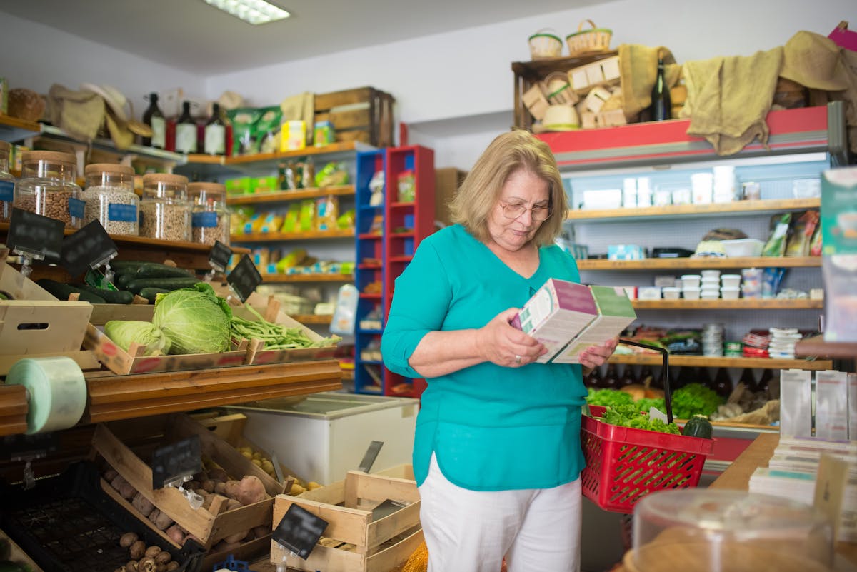 10 Sneaky Grocery Store Scams That Are Easy To Fall For 3 An elderly woman examines a product in a grocery store in Portugal.