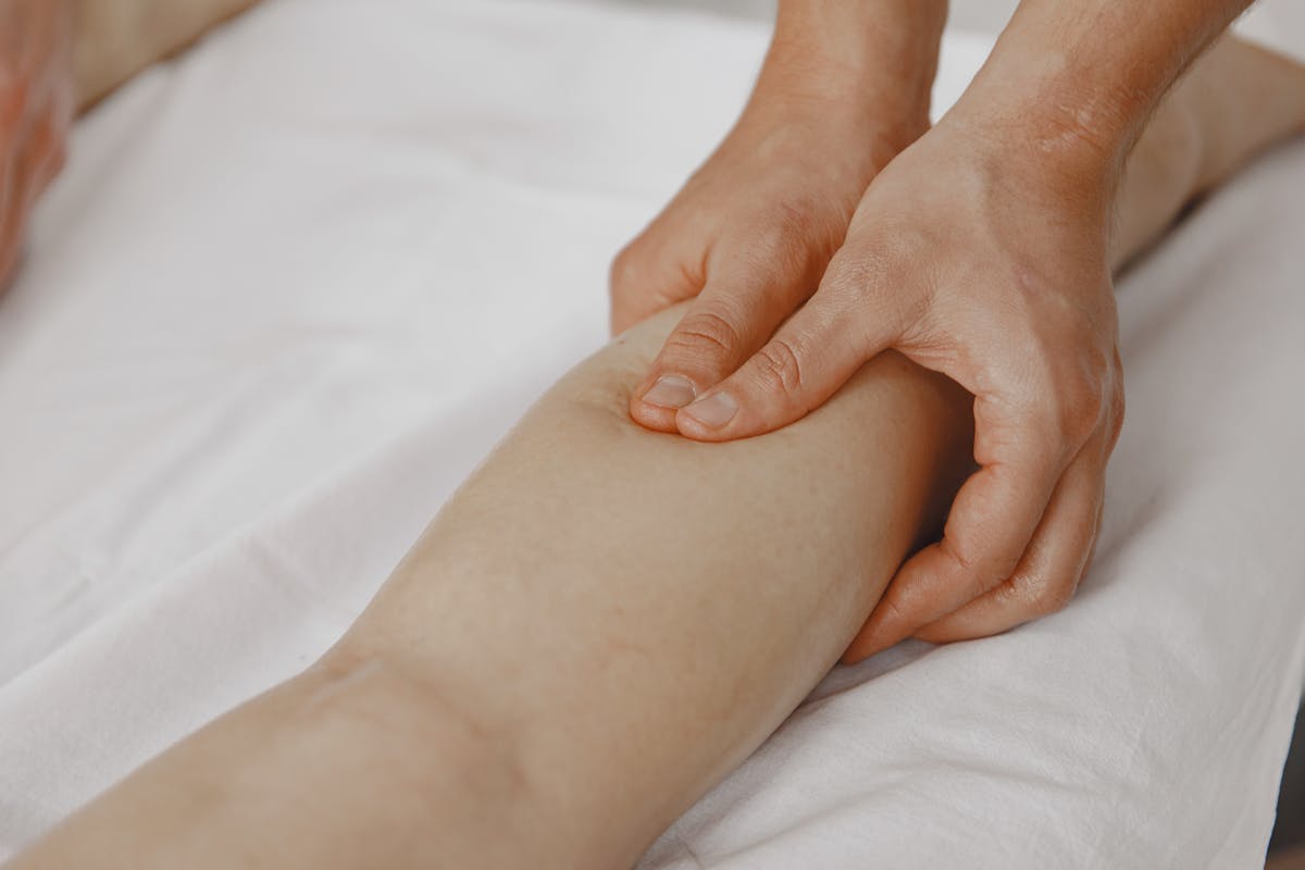 12 Heart Warning Signs Too Many People Brush Off Until It Gets Serious 2 Close-up image of a massage therapist applying pressure on a client's leg for muscle relaxation.