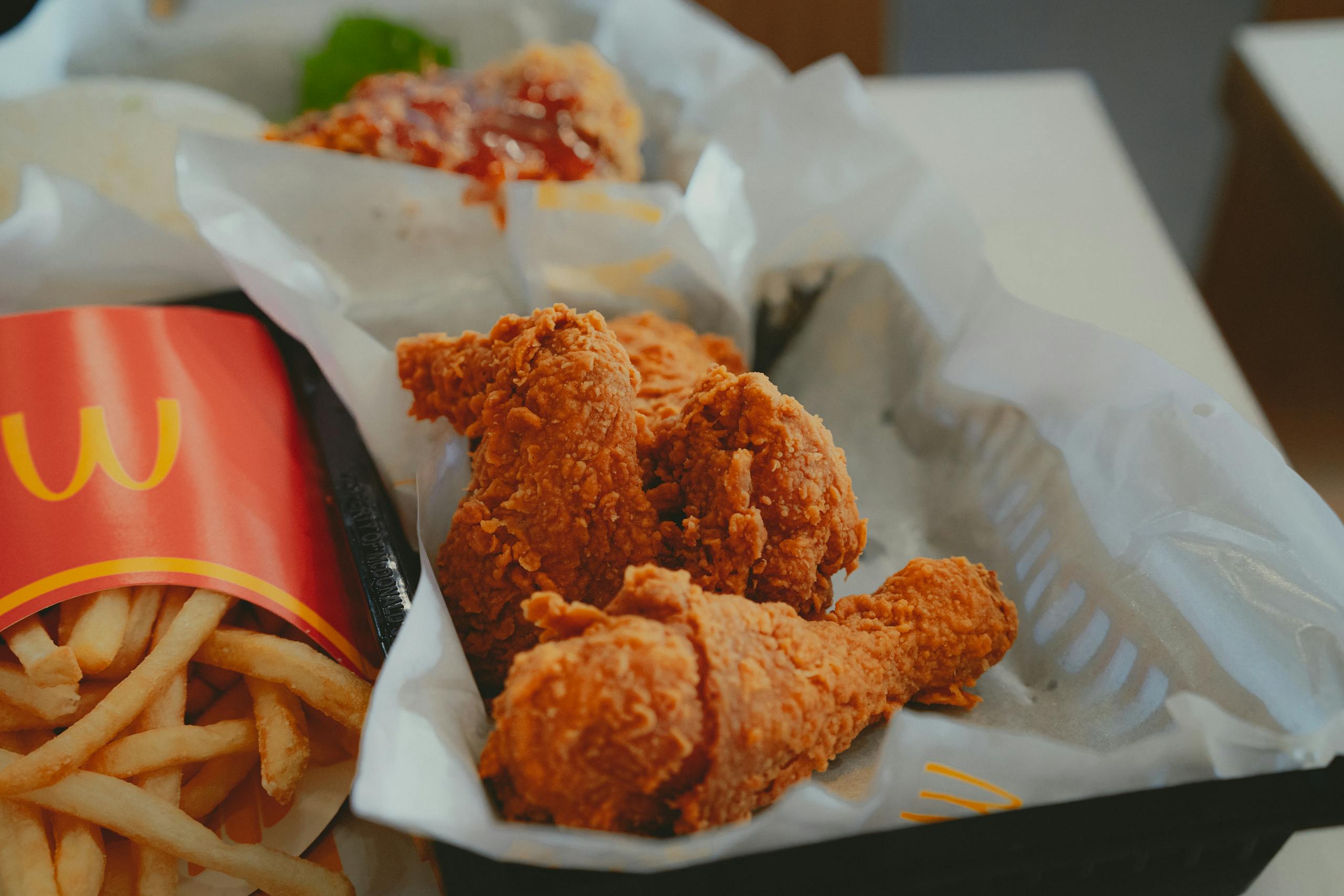 Close-up of crispy fried chicken and fries in a fast food restaurant.