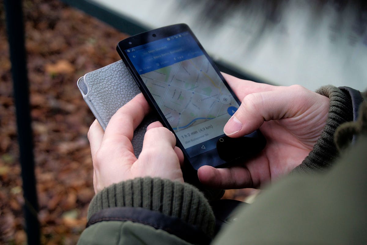 Boomers Are Saying Nope to These 13 Things as Life After 60 Gets More Intentional 2 Close-up of hands using a map app on a smartphone outdoors, showcasing GPS navigation.