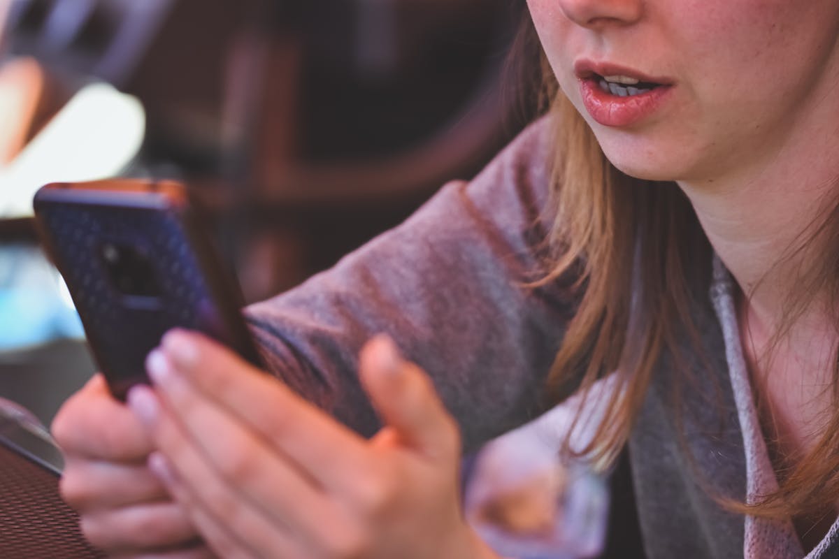 8 Ways Constant Texting is Destroying Your Relationship 3 Close-up of woman using smartphone inside, demonstrating focus on mobile technology and communication.