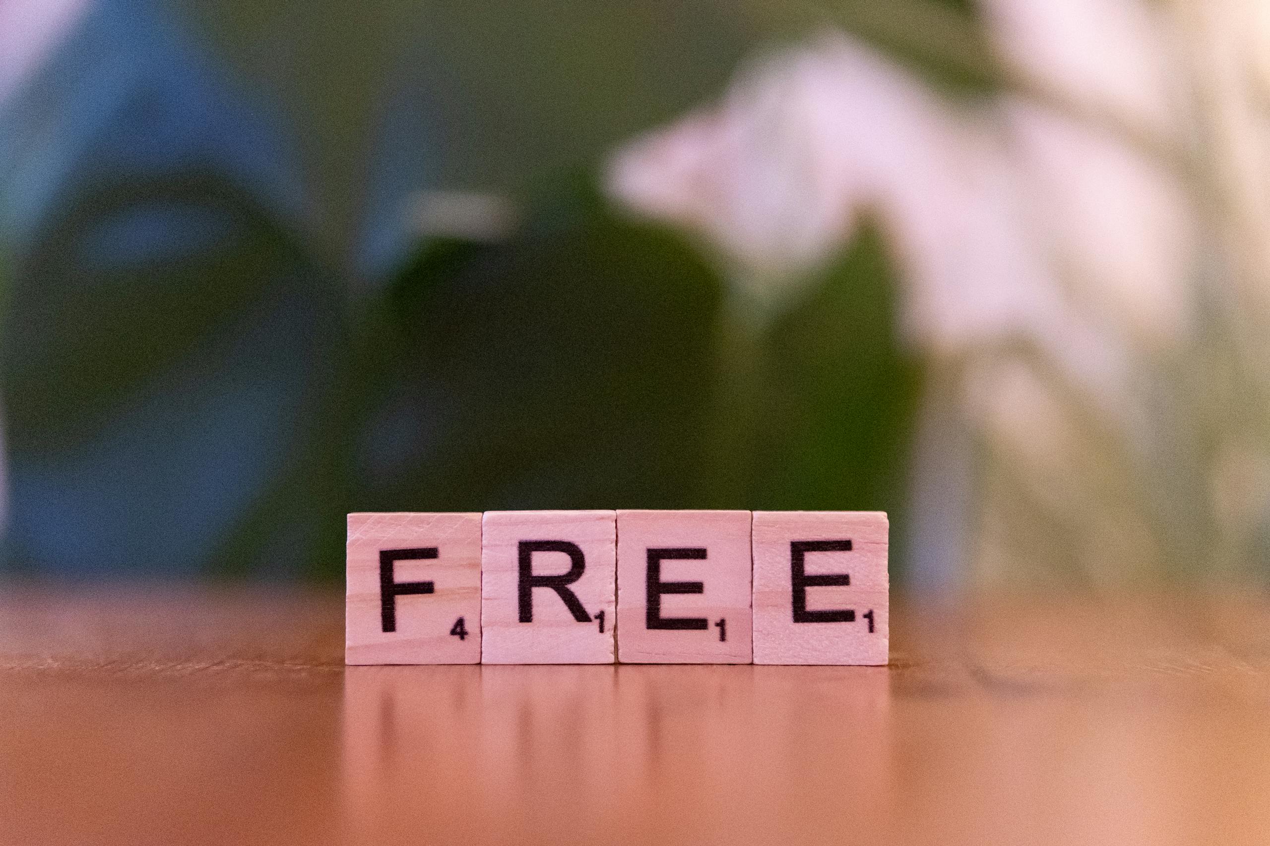 12 Sneaky Tricks Companies Use to Drain Your Wallet 5 Close-up of wooden Scrabble tiles spelling 'FREE' on a table.