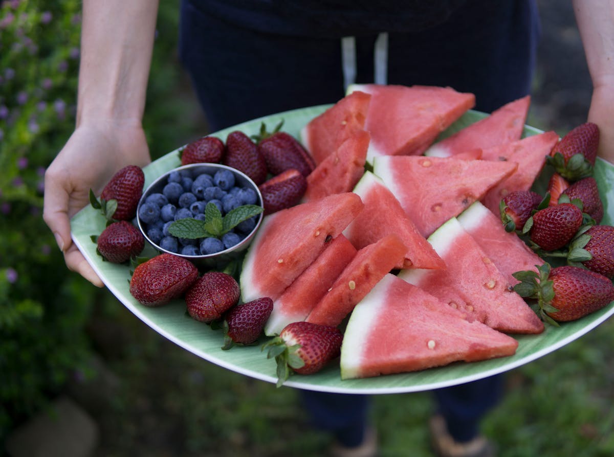 Delicious platter of fresh watermelon, strawberries, and blueberries, perfect for a healthy snack.