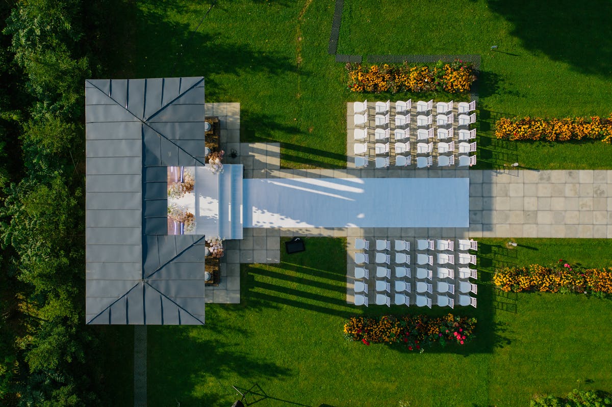 Drone shot of beautifully prepared outdoor wedding venue with chairs and gazebo.