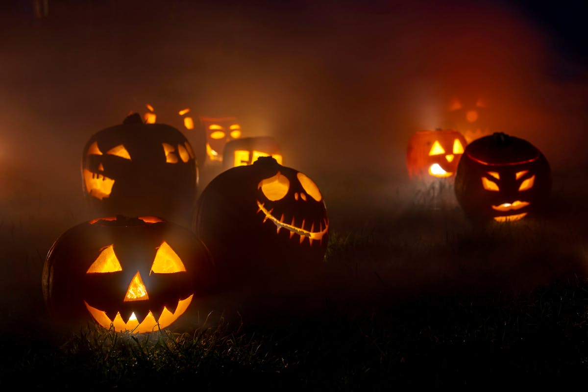 10 Truly Evil People Who Used Halloween as the Perfect Cover 1 Eerie glowing jack-o'-lanterns in a foggy outdoor setting, perfect for Halloween themes.