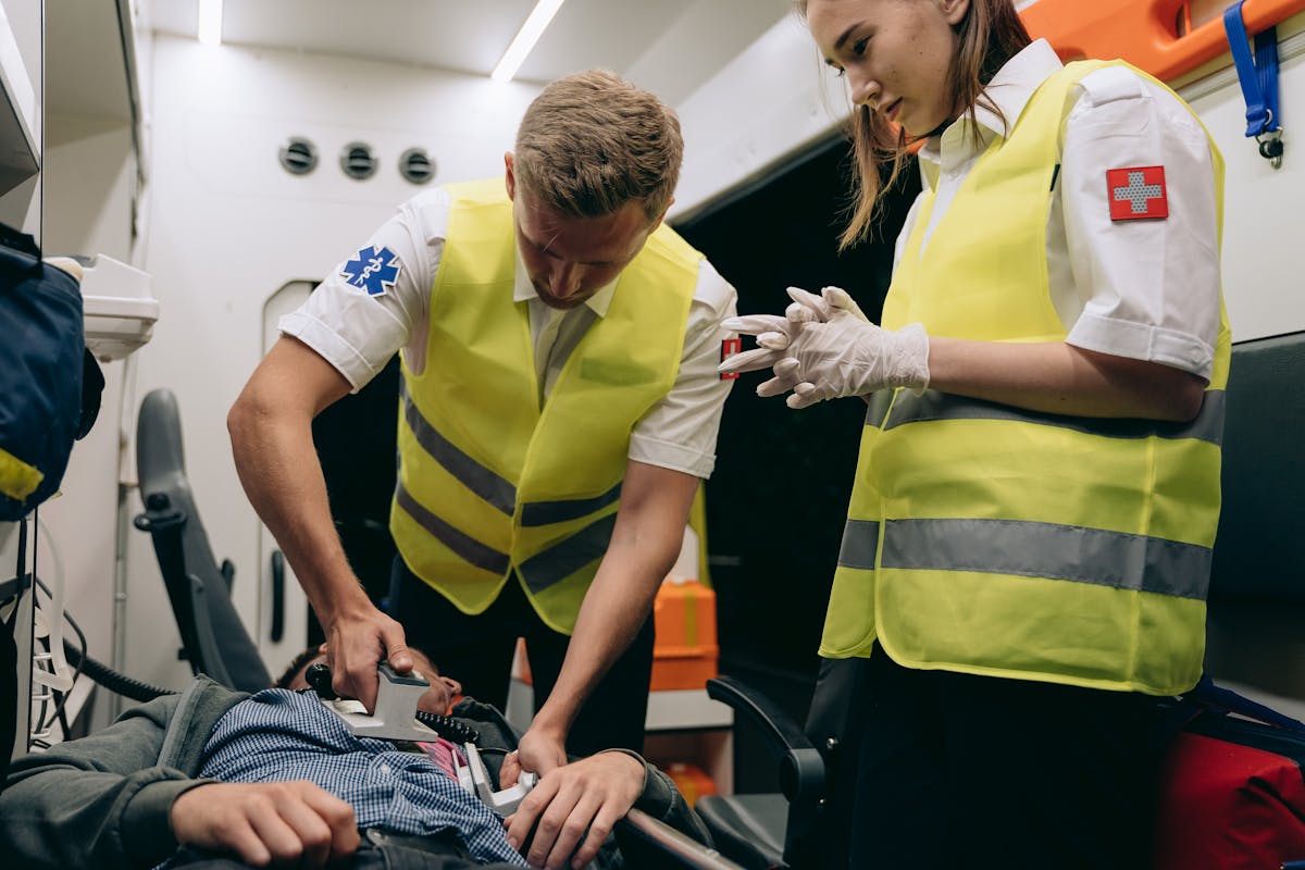 Emergency responders perform lifesaving procedures inside an ambulance.