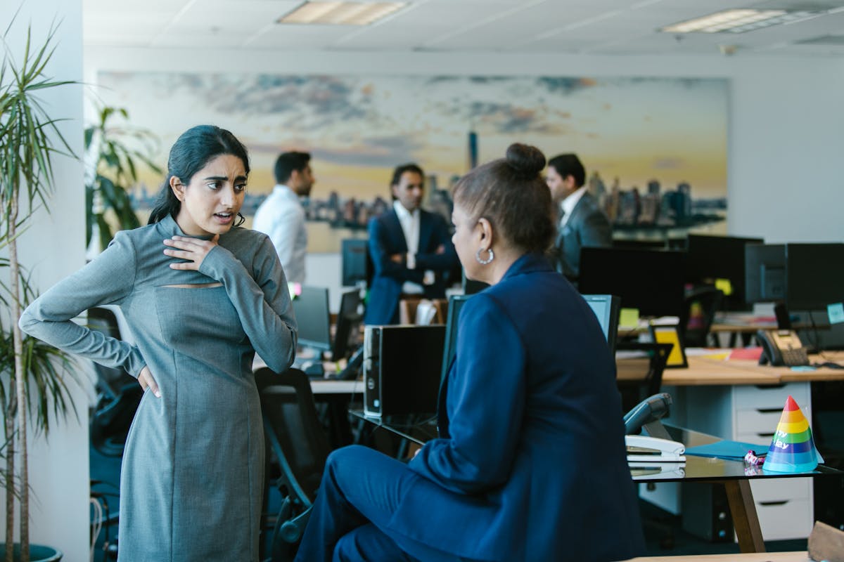 10 Gen X habits bosses believe are career killers 2 Employees engage in a lively discussion in a contemporary office setting.