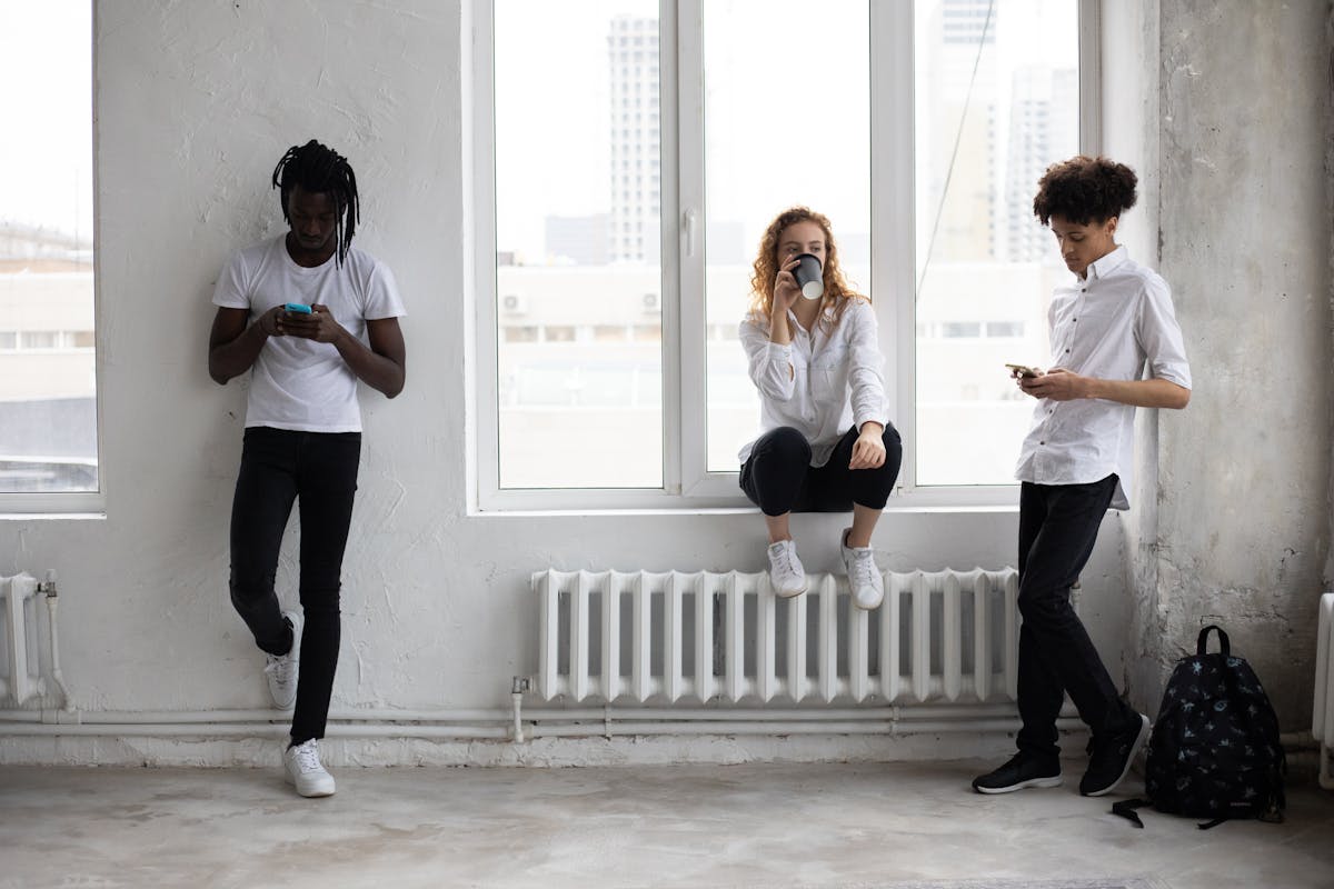 10 Painful Signs Someone Secretly Dislikes You More Than They Admit 2 Full body of diverse classmates drinking coffee and surfing smartphones during break in spacious room