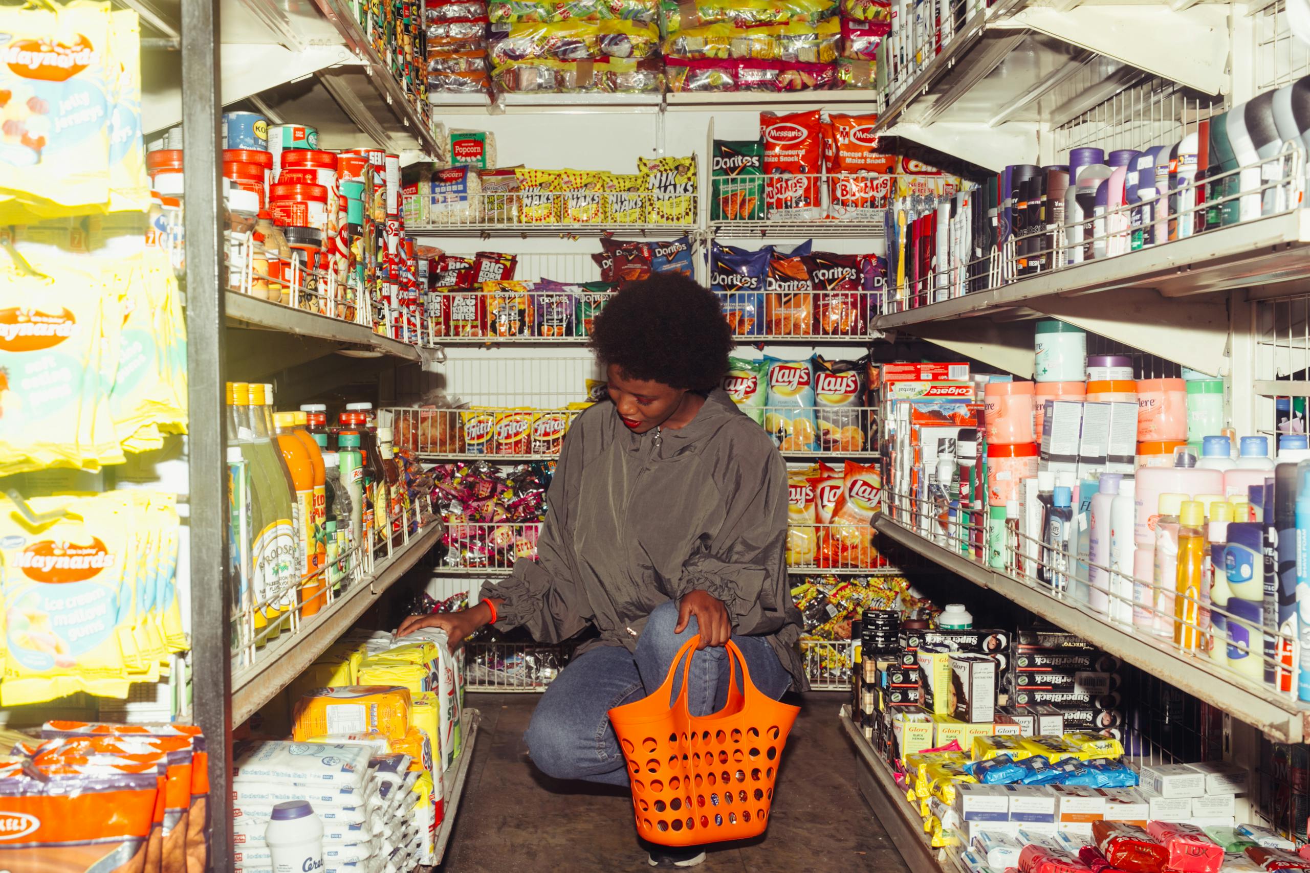 8 Everyday Rip Offs Hiding In Plain Sight 4 Full length of adult ethnic female buyer selecting goods while squatting with shopping bag among grocery shelves
