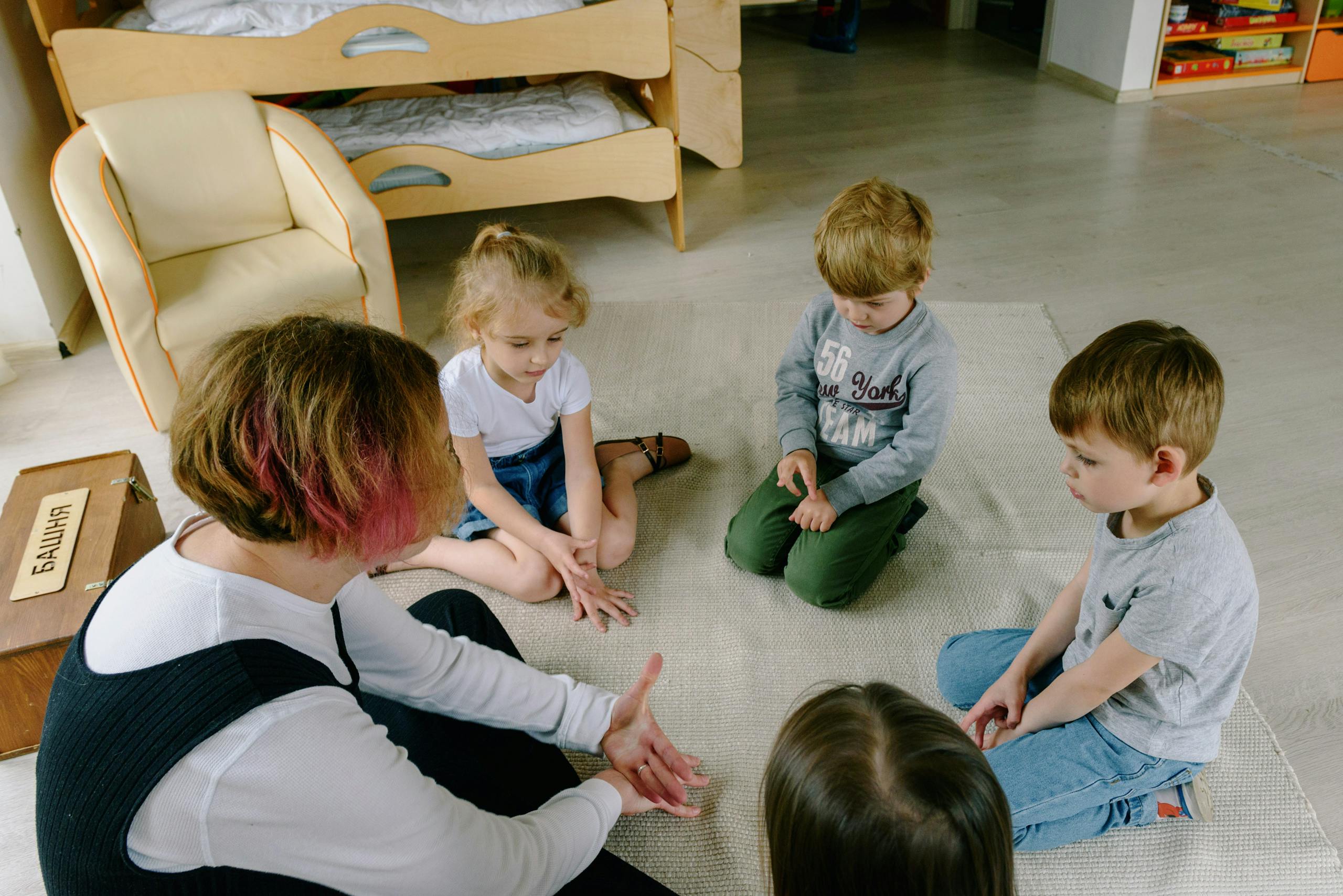 10 Outrageous Ways Your Local School Is Quietly Brainwashing Your Kids 3 Group of children engaged in a learning activity, sitting in a circle on the classroom floor.