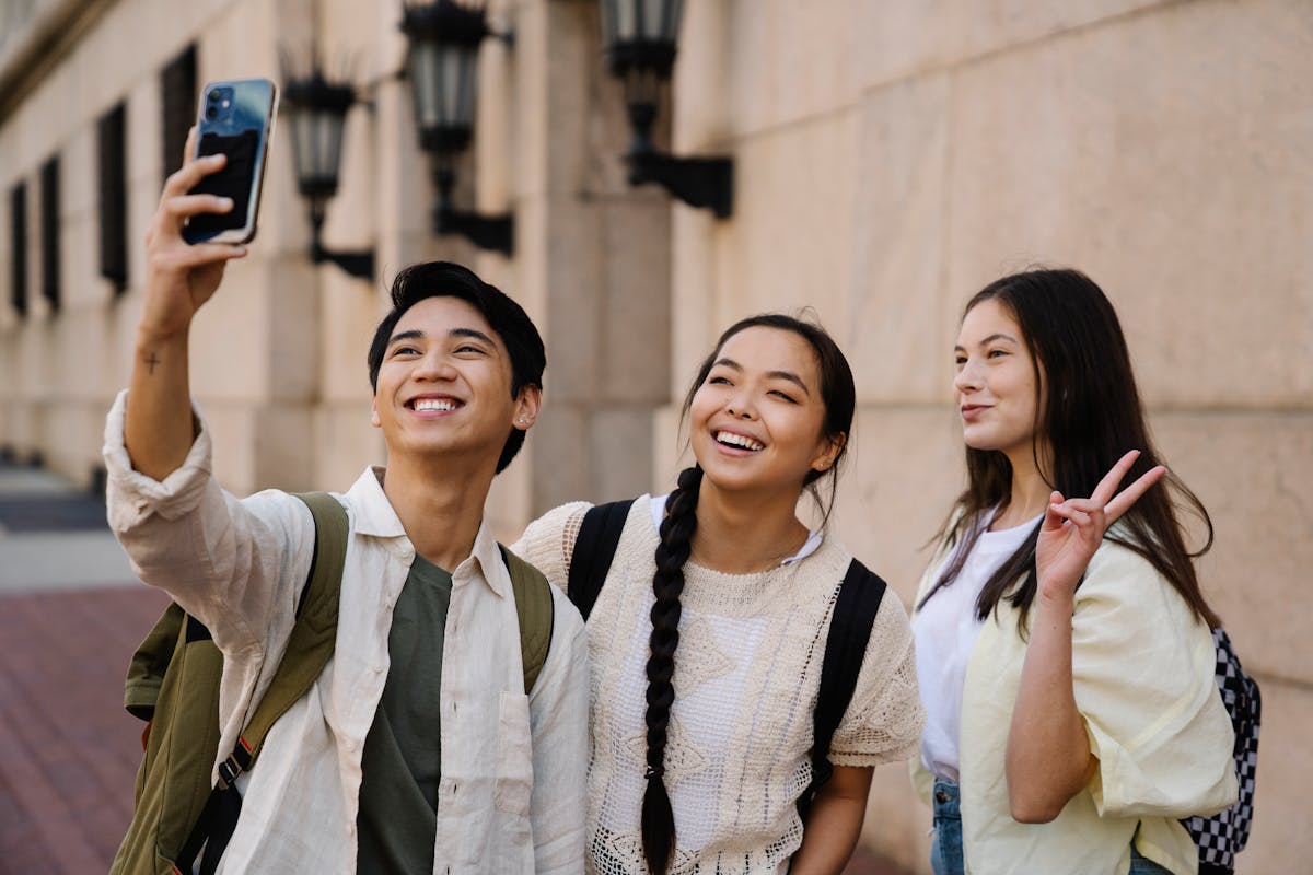 10 Gen Z Habits That Quietly Irritate Millennials 3 Group of young friends capturing a happy moment with a selfie outdoors.
