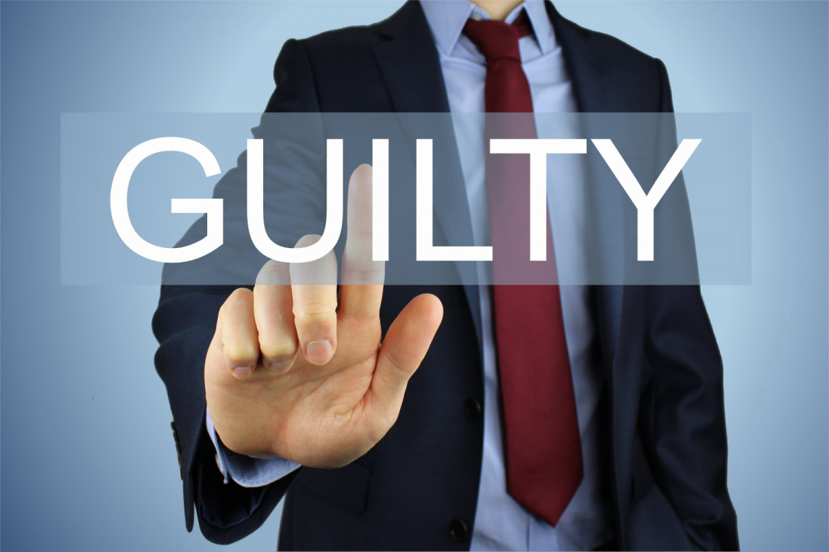 A man raising a finger and the name guilty infront