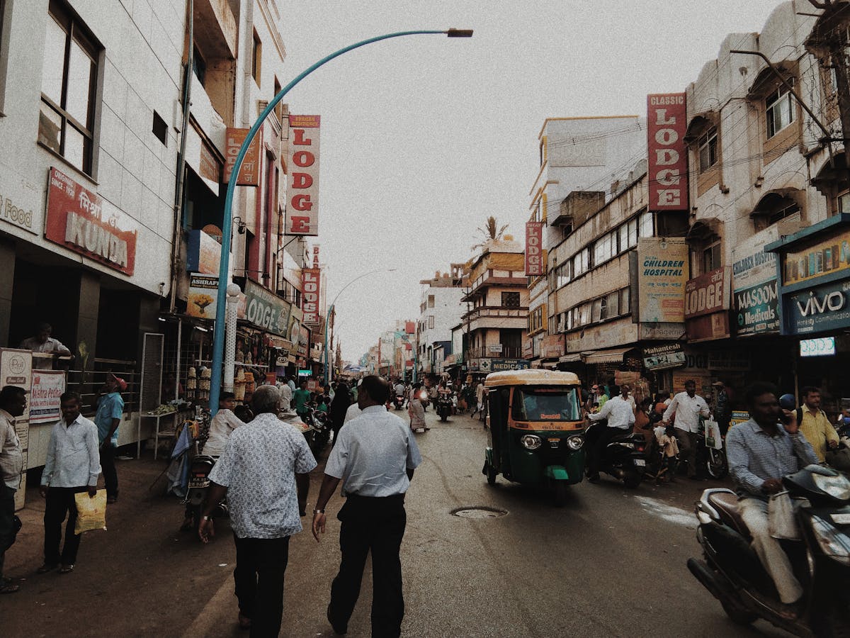 8 Cities With the Worst Air Quality Globally 2 Lively street in Belgaum, India with people, shops, and vehicles in an urban setting.