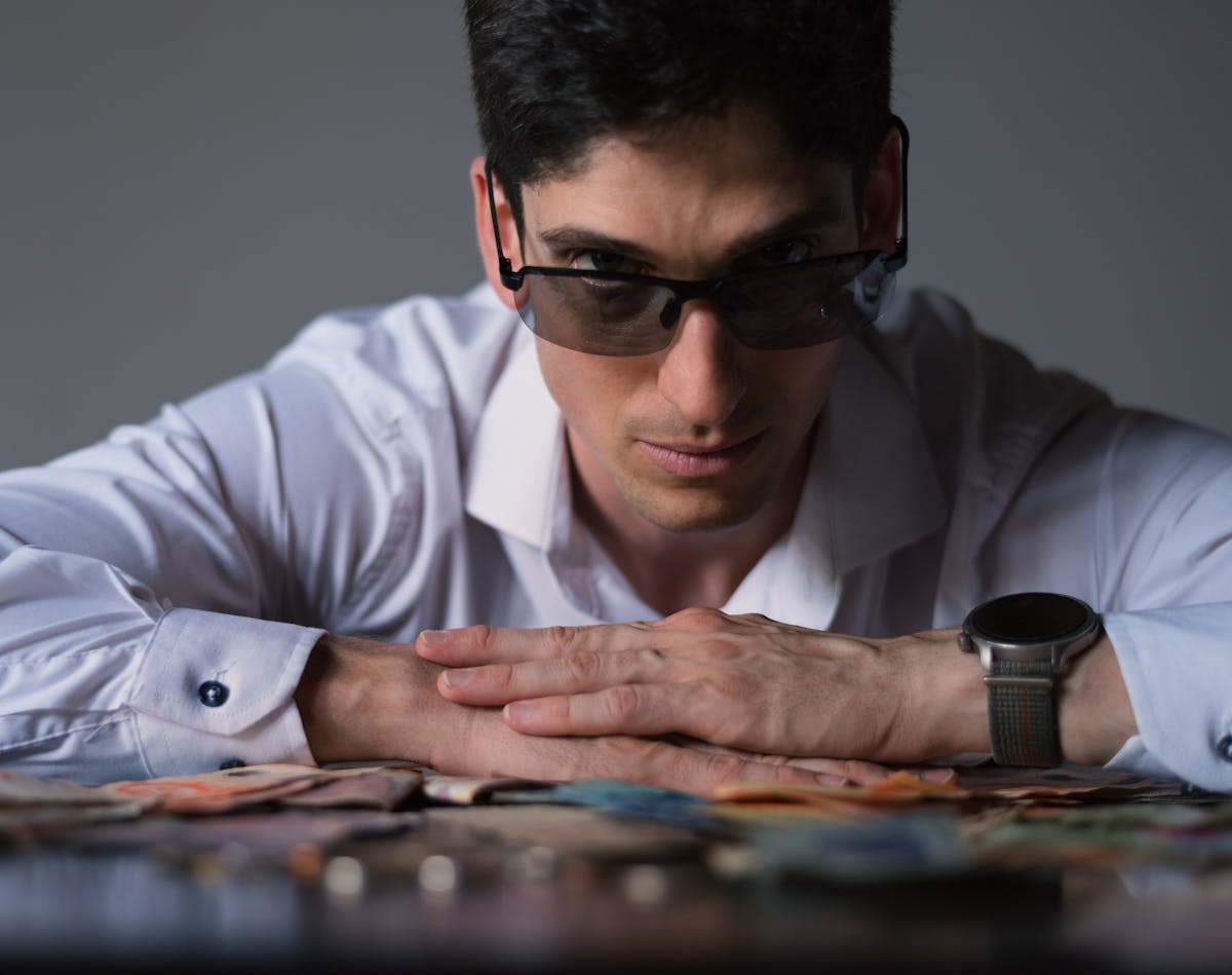 10 Brutal Truths Men Secretly Struggle With Emotionally 2 Man in sunglasses with diverse currency, exuding confidence and wealth