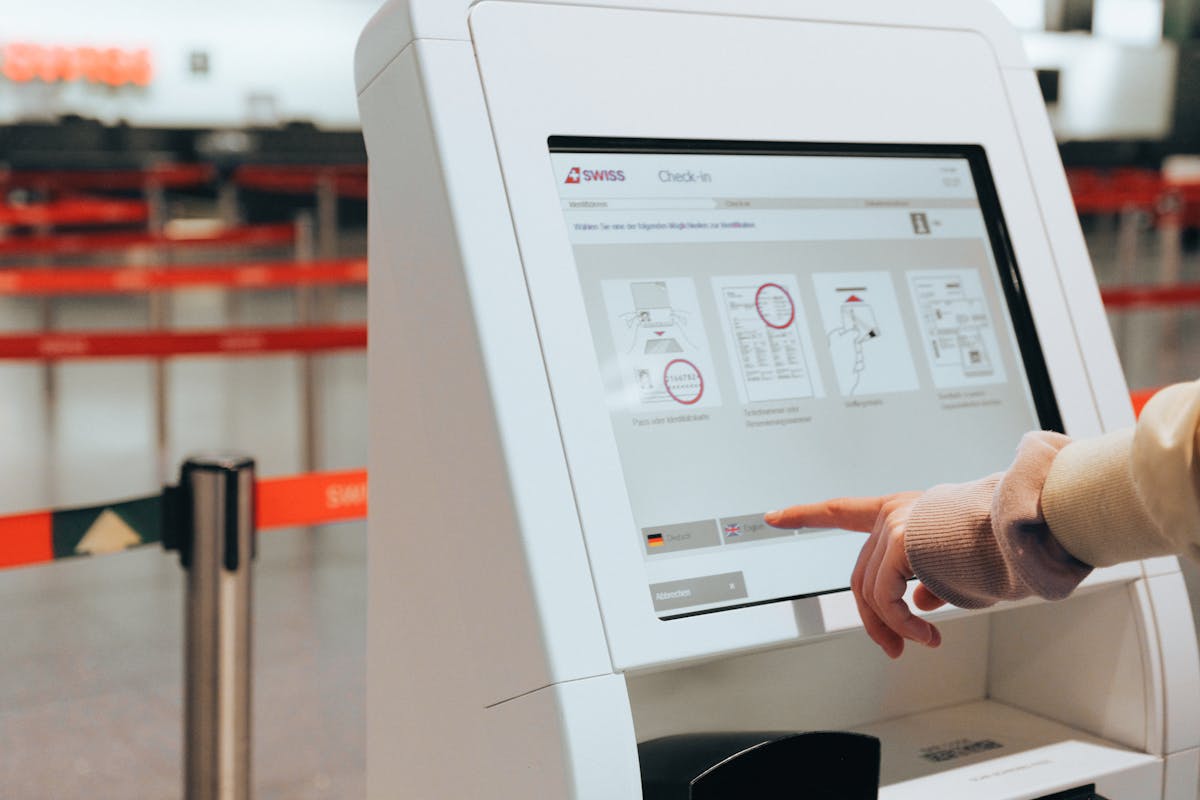 Passenger using self-service check-in kiosk at airport for convenient travel experience. Self-Checkout Kiosk