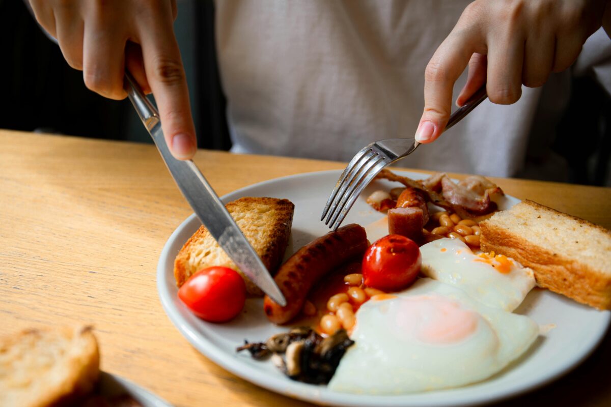 a-person-holding-silver-utensils