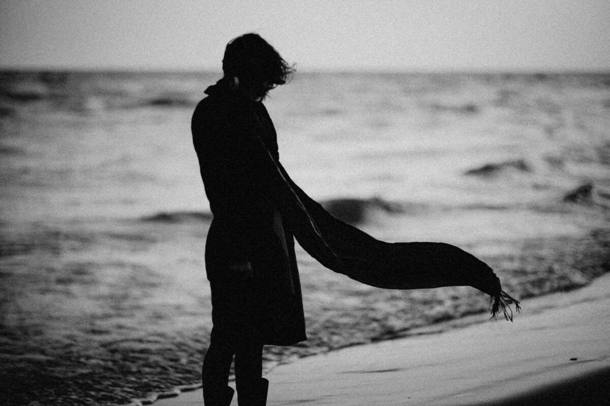 8 Painful Truths About Rebound Relationships People Learn Too Late 1 a-silhouette-of-a-person-wearing-a-scarf-on-a-beach