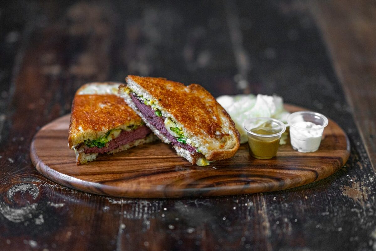 12 Delicious Foods That Were Born from Happy Accidents 3 /closeup-of-a-toasted-sandwich-with-ham-and-salad-on-a-wooden-cutting-board-