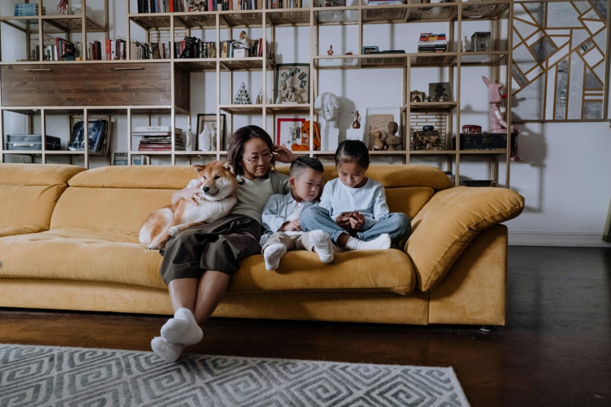 7 Petty Reasons Parents Get Irritated When Their Kids Use Phones 3 mother-and-two-children-sitting-on-sofa-with-shiba-inu-dog