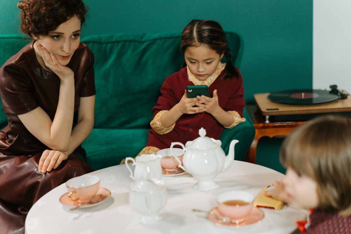 7 Petty Reasons Parents Get Irritated When Their Kids Use Phones 4 a-woman-sitting-next-to-the-girl-holding-a-smartphone