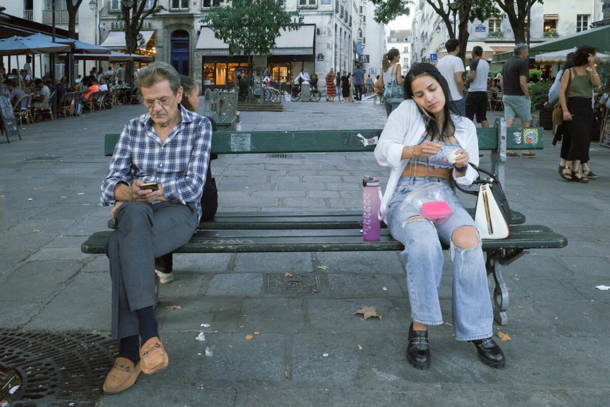 /man-and-woman-sitting-on-urban-bench-