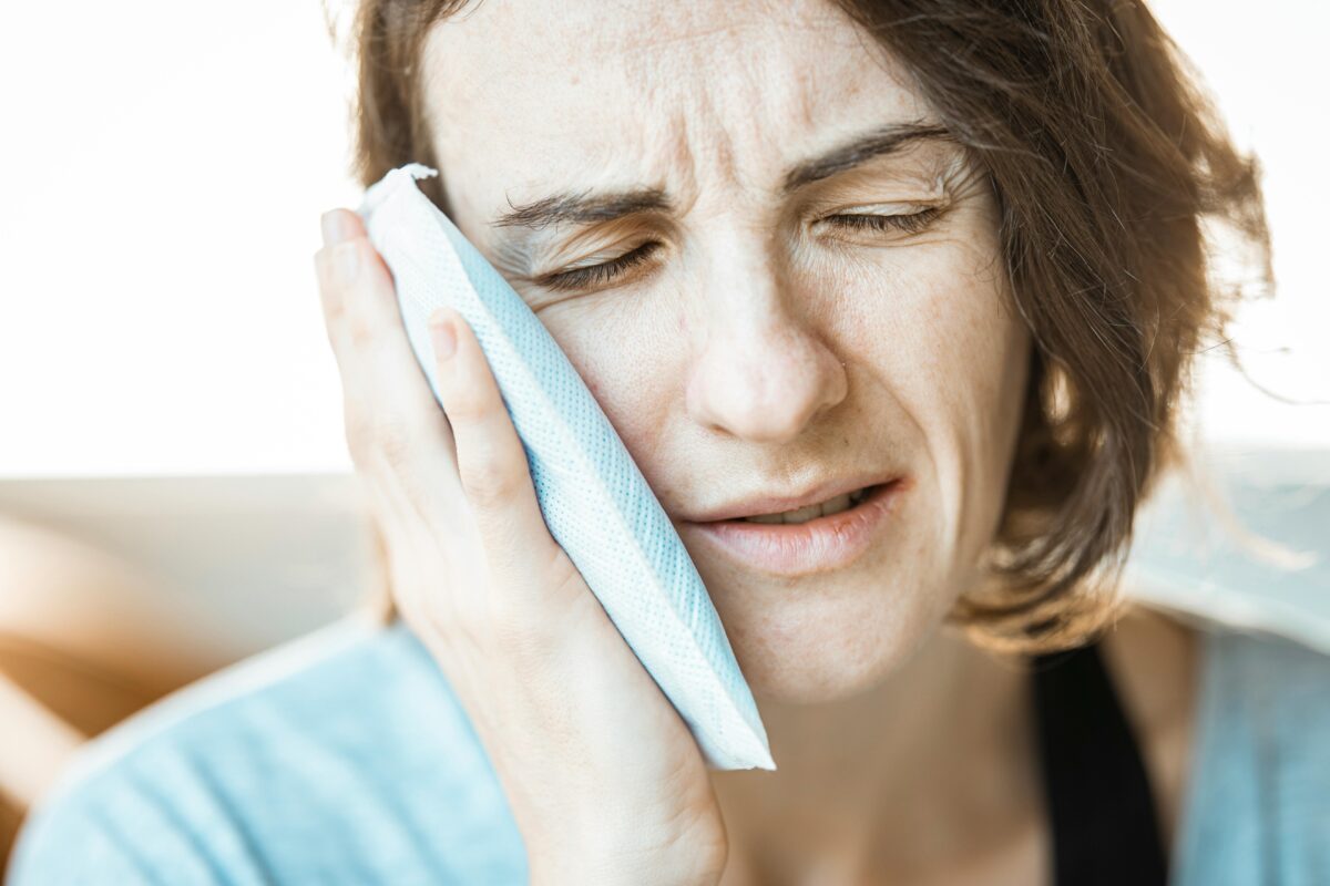 woman-putting-cold-compress-on-her-face
